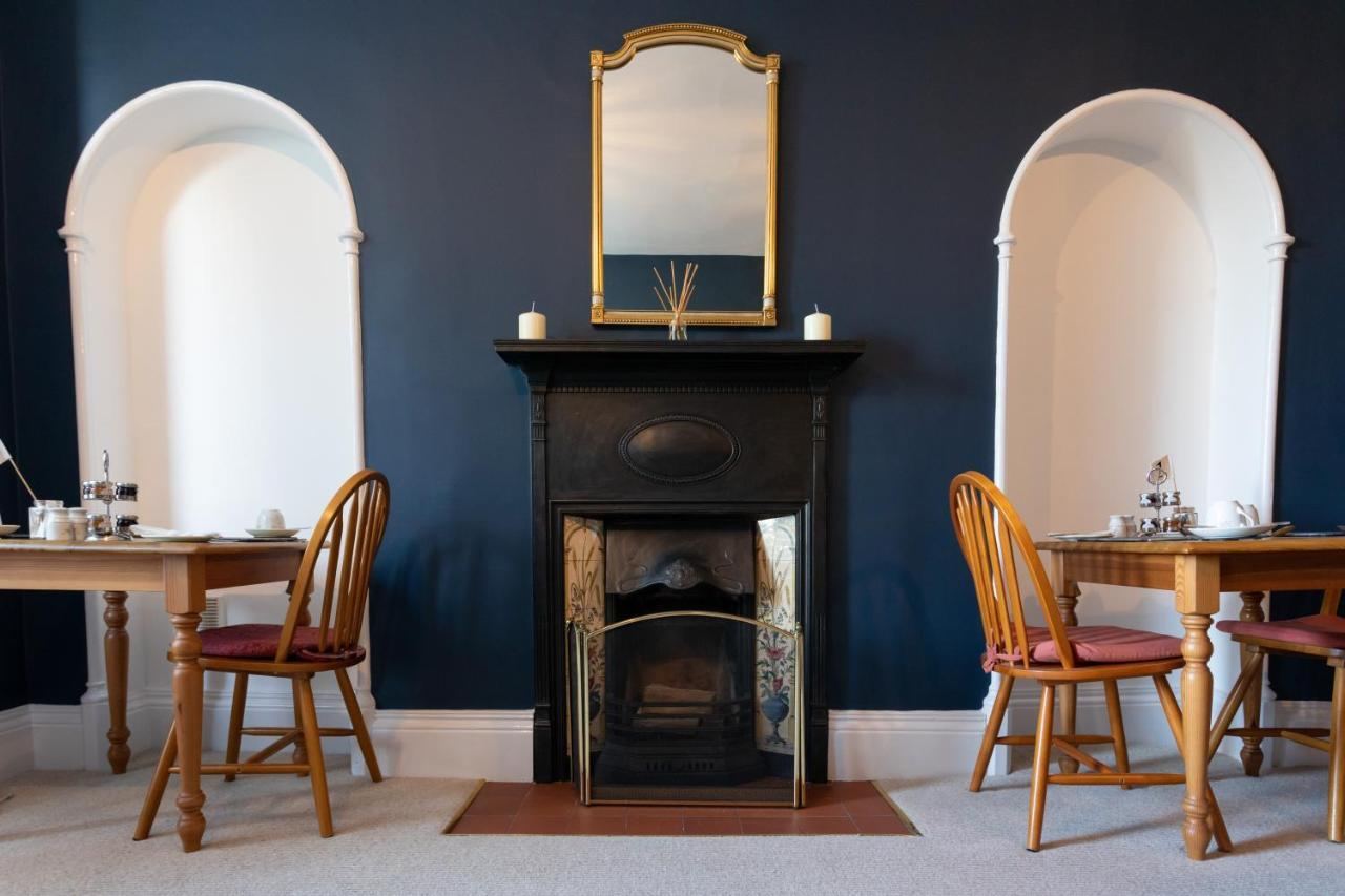 Breakfast room with Victorian fireplace and set tables