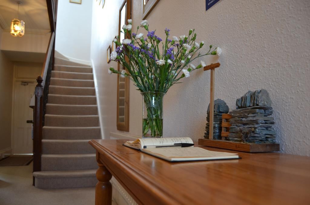 Entrance hallway with staircase, flowers and visitors book